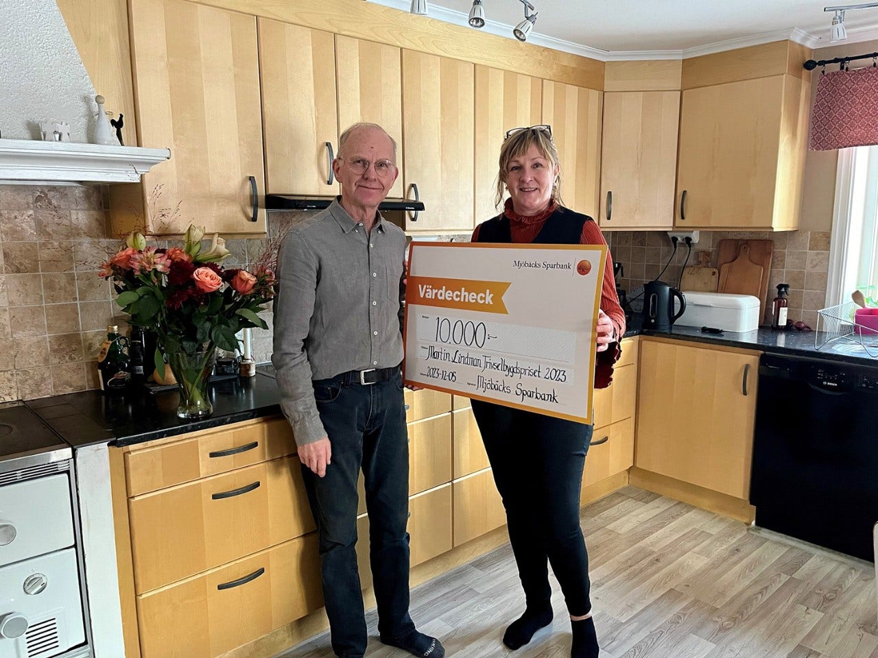 Lena Karlsson räcker över Trivselbygdspriset 2023 till Martin Lindman.